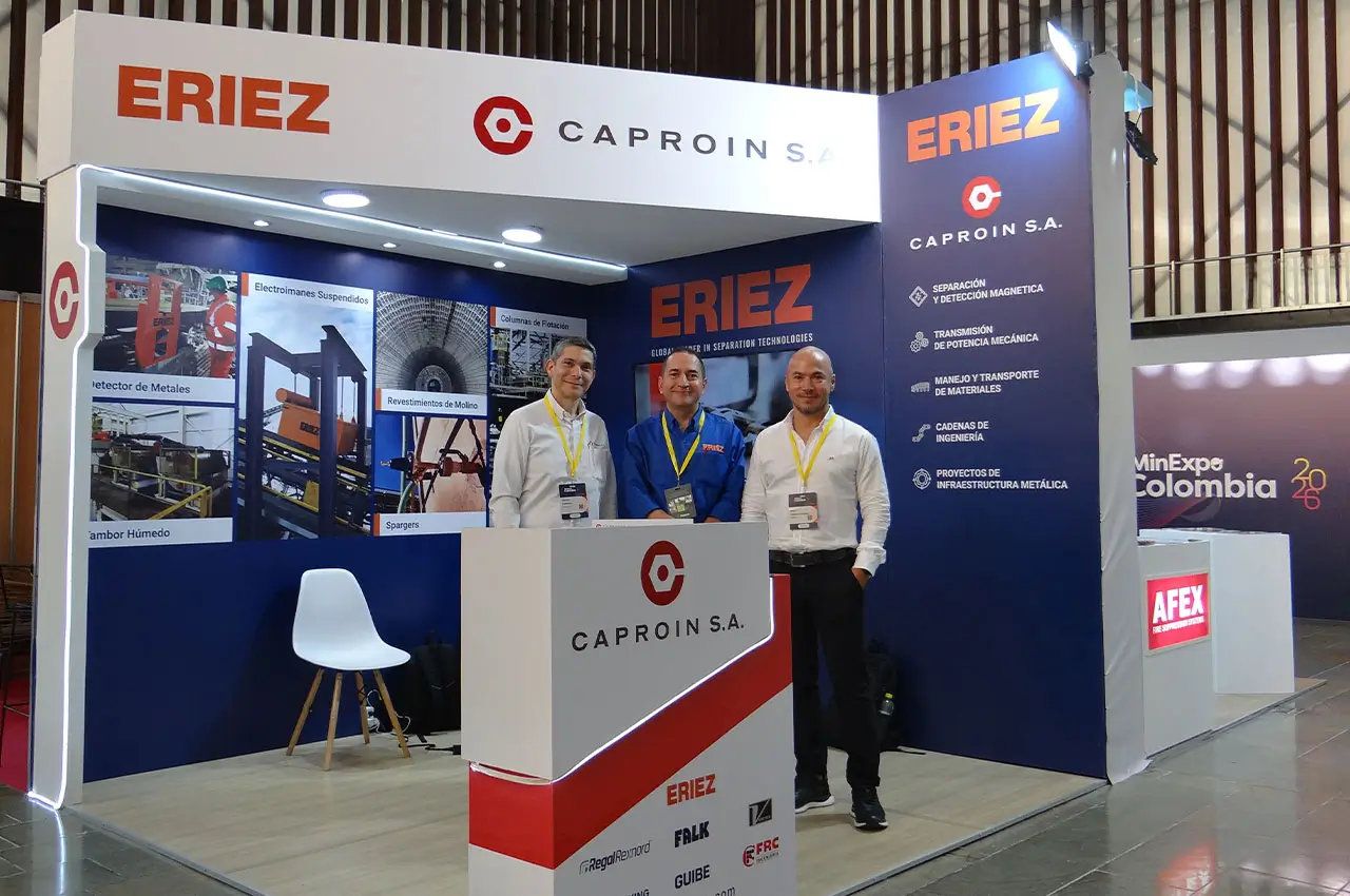 Stand de Caproin y Eriez en MinExpo 2026. De izquierda a derecha: Foción Cormane, Juan Manuel Mejía y Raúl Ochoa del equipo de Caproin, posando en el espacio de exhibición técnica en Plaza Mayor, Medellín.