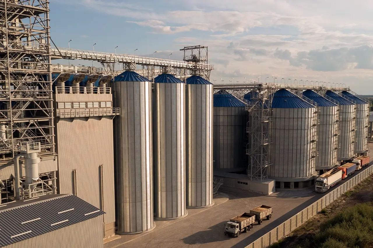 Vista general de una gran planta industrial con silos metálicos de almacenamiento.